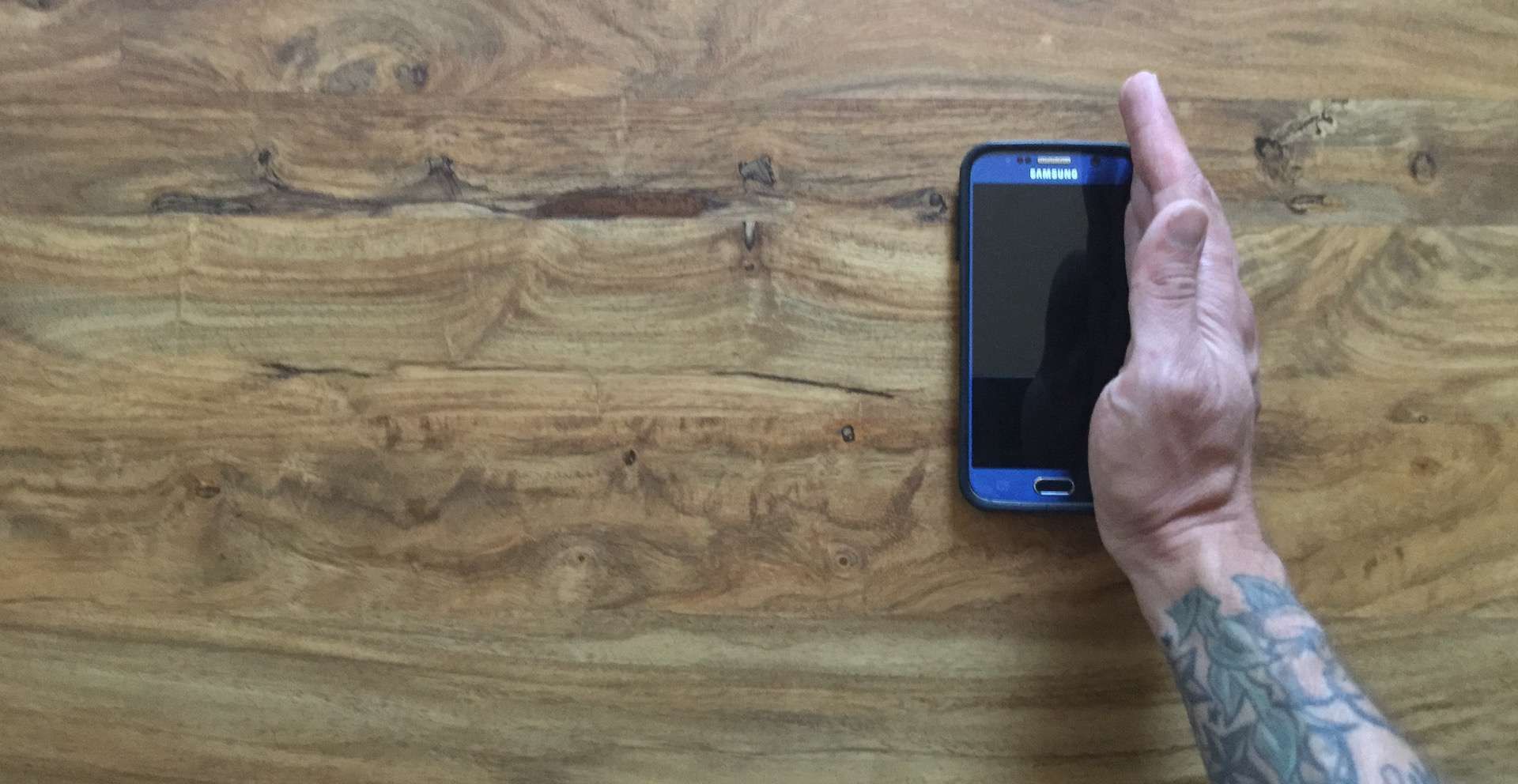 Мужчина's hand is vertical on the edge of a Samsung S6.