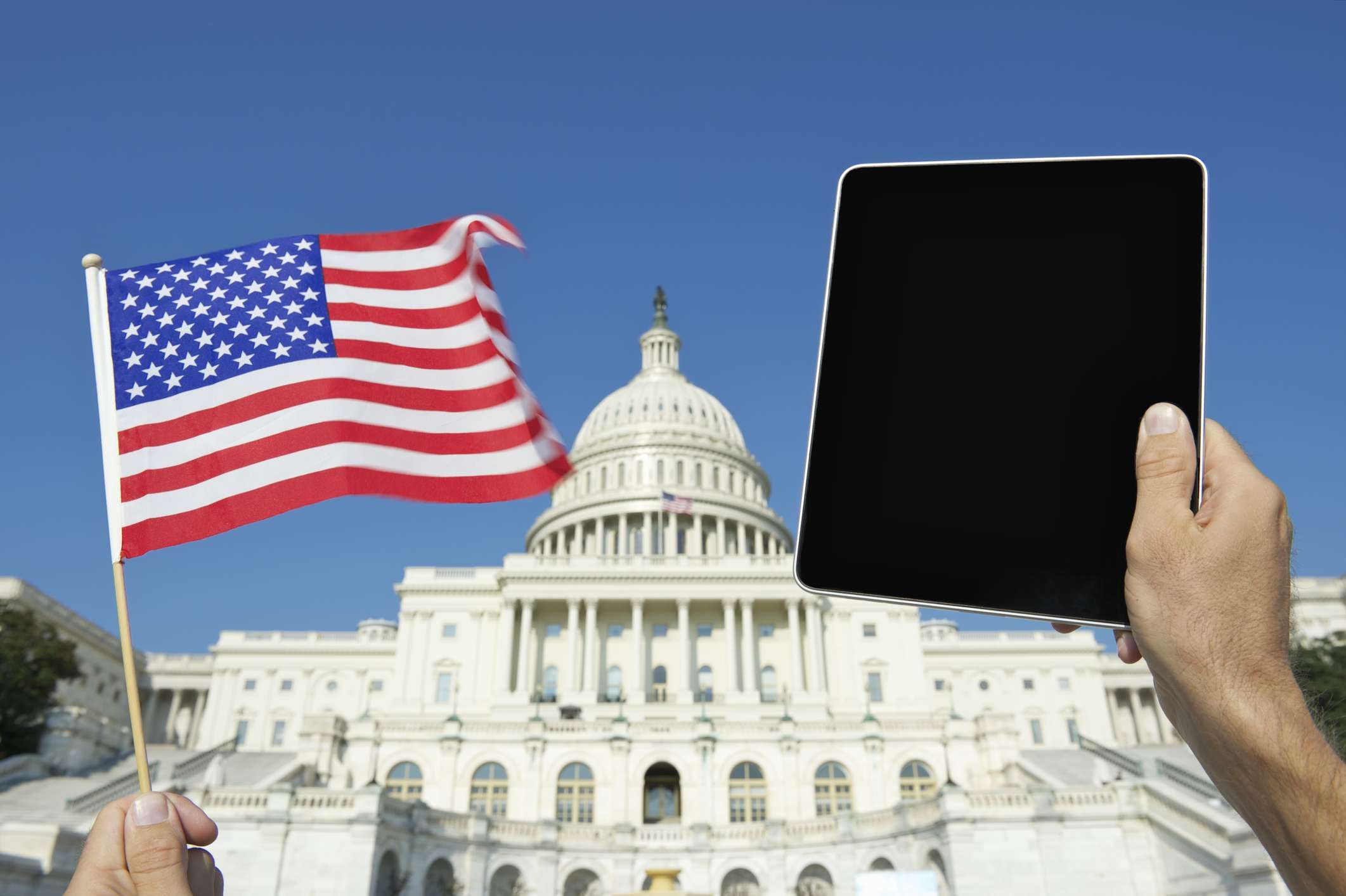 Руки держат американский флаг и цифровой планшет в Белом доме