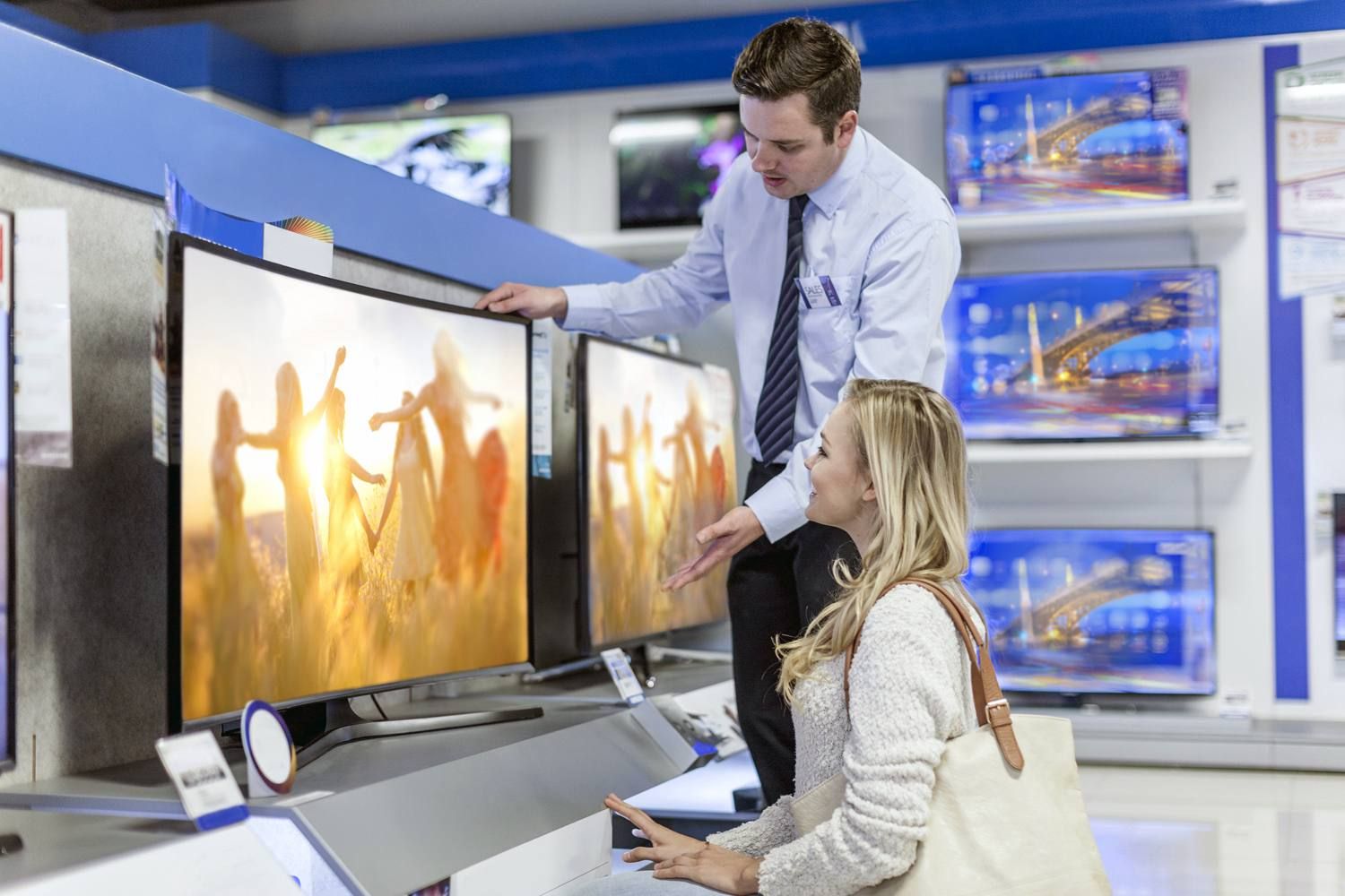 Продавец помогает женщине делать покупки для телевидения