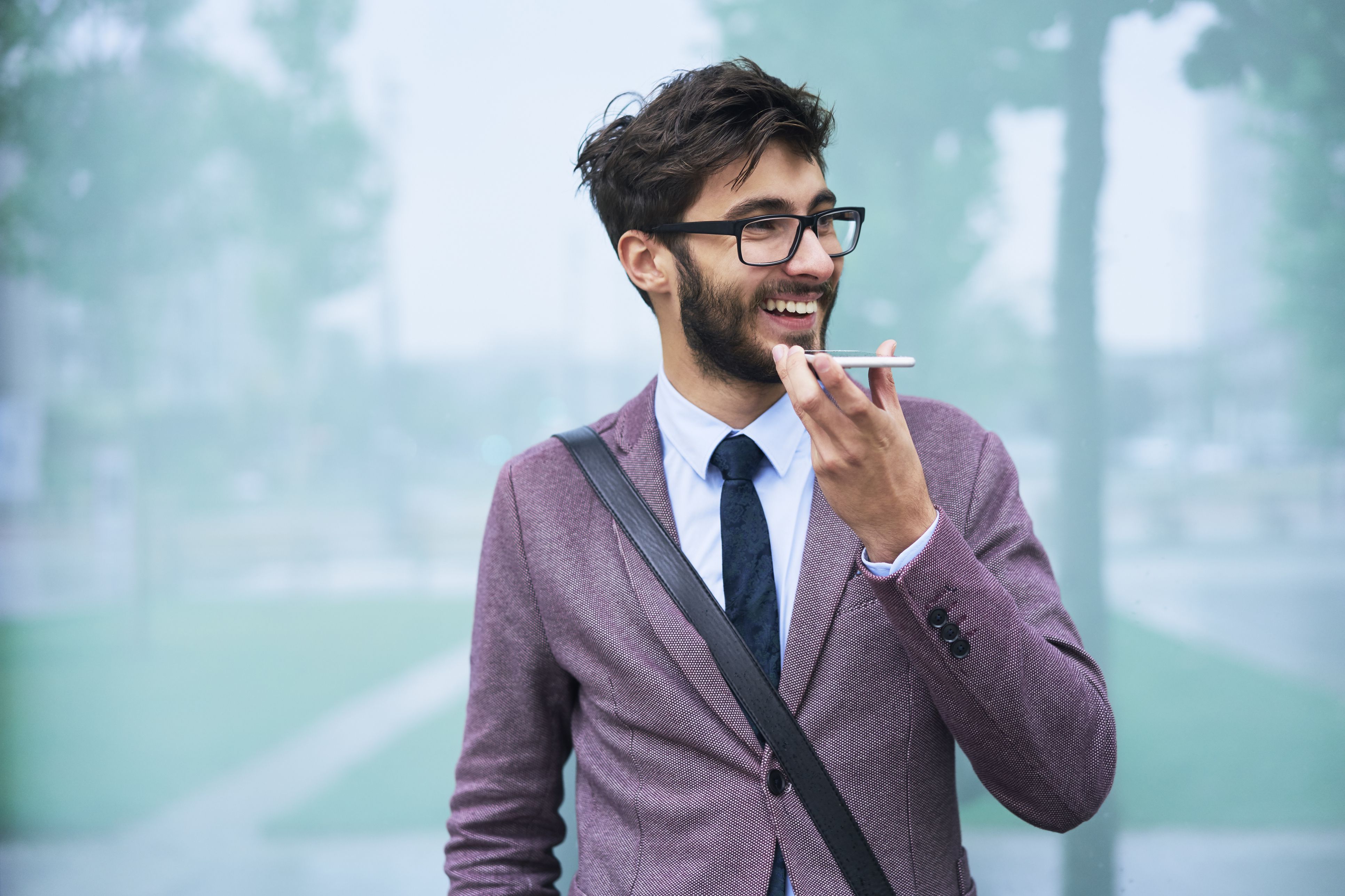 Портрет счастливого молодого бизнесмена на телефоне outdoors