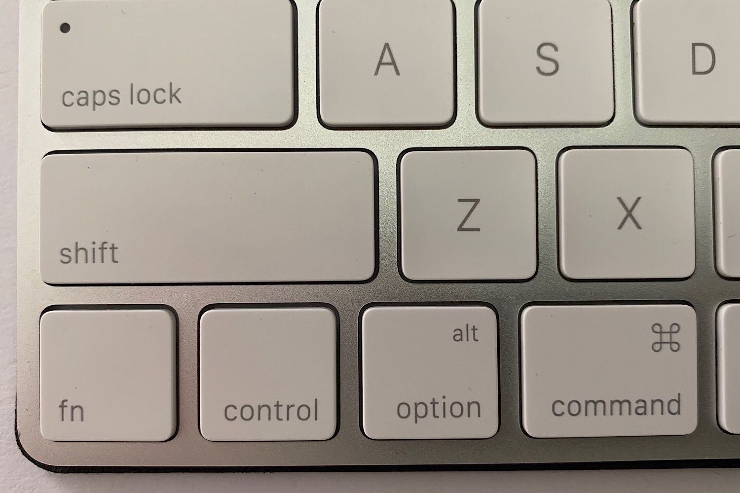 Увеличенная фотография нижней левой магической клавиатуры с видимыми клавишами Command + Z и Shift + Command + Z.