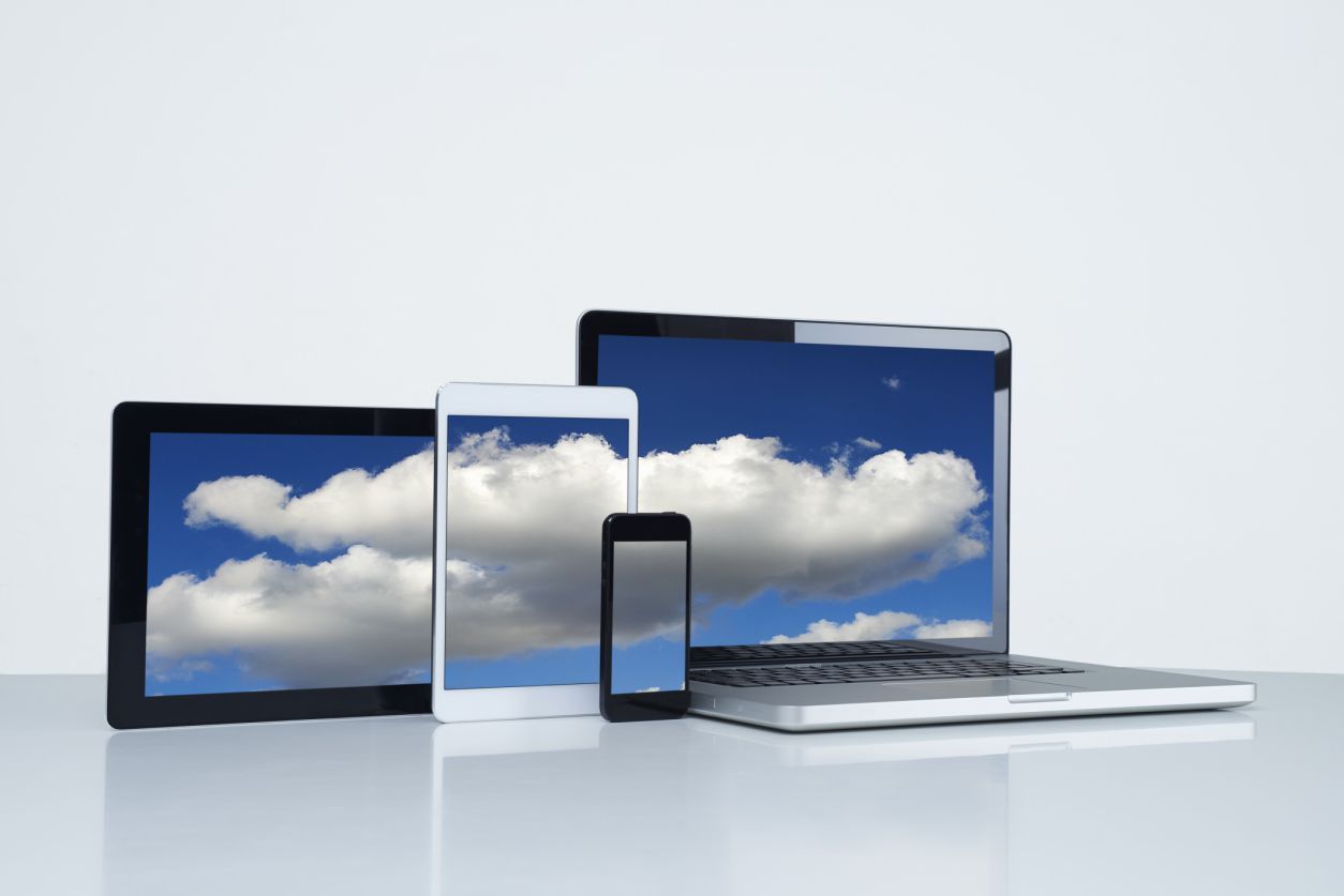 Ноутбук, телефон и планшет - все с одной и той же фотографией на облаках на экранах