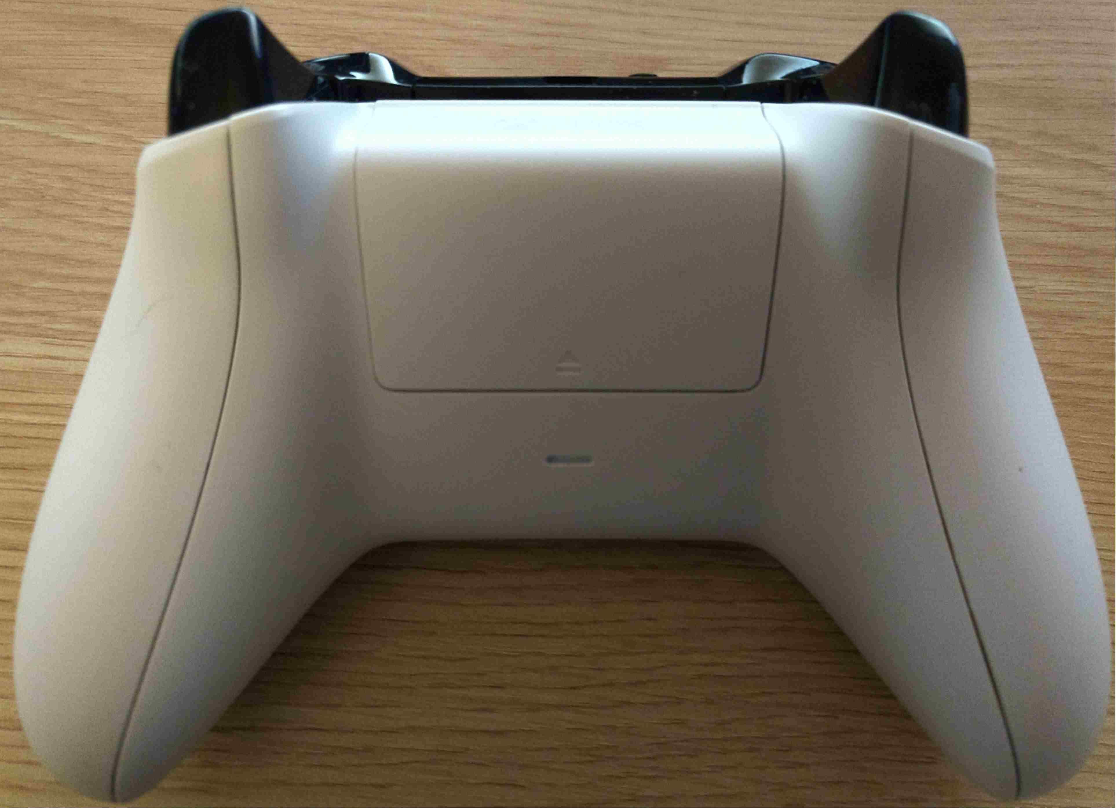 Задняя сторона контроллера Xbox One, показывающая расположение батарейного отсека.