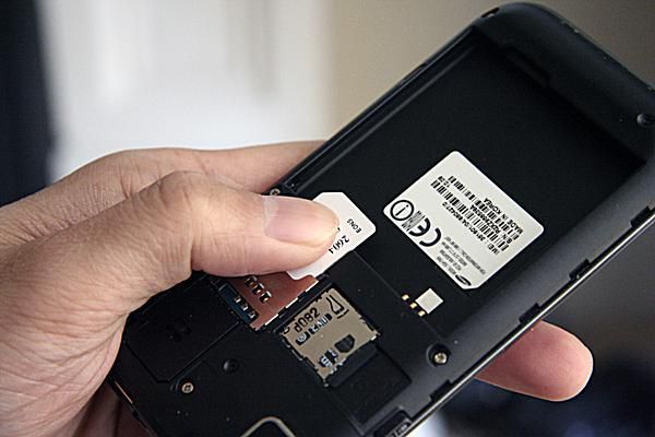 Рука, выдвигающая SIM-карту из Galaxy S Vibrant