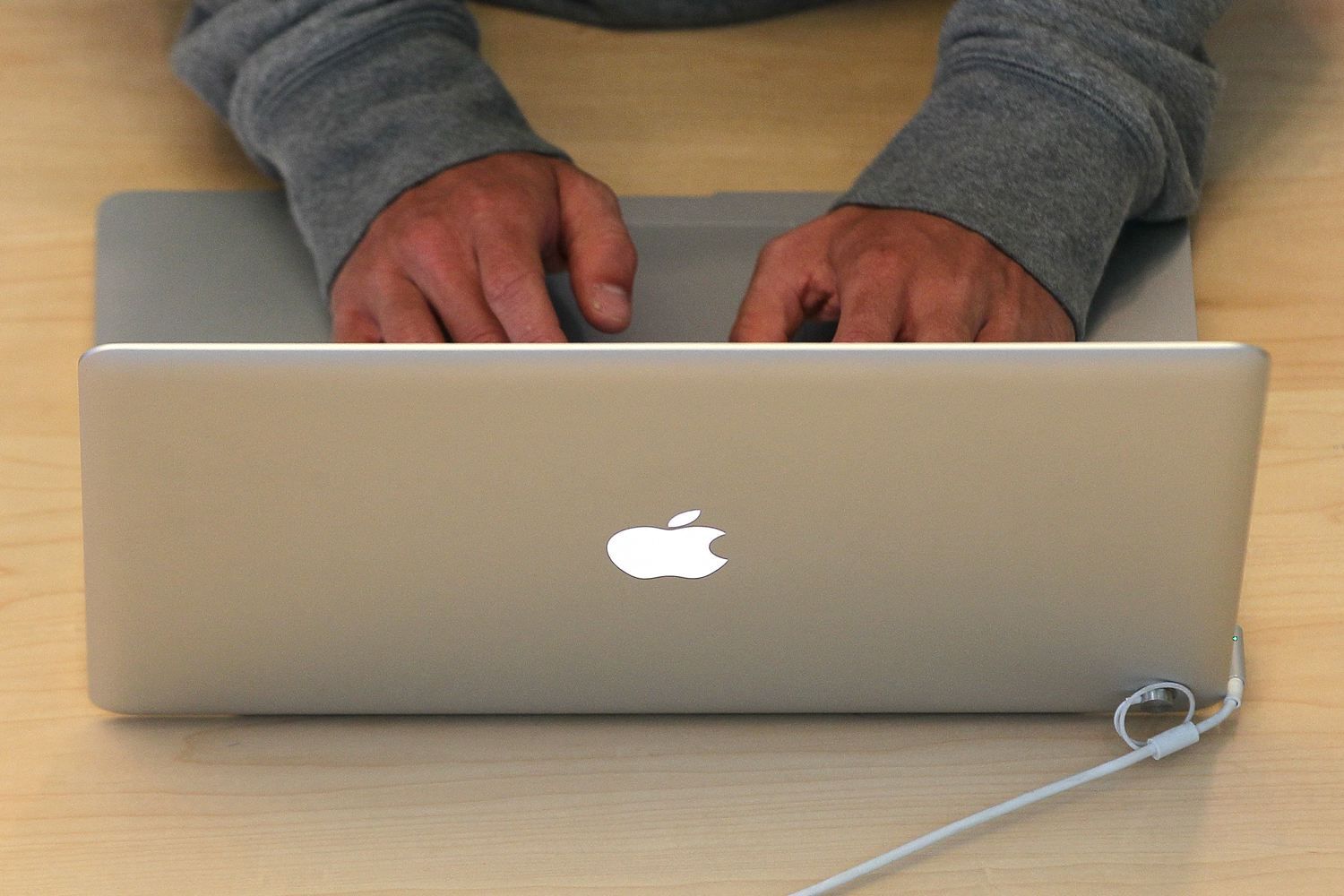 Человек печатает на ноутбуке Apple