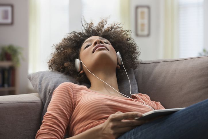 Женщина носить наушники и слушать музыку на планшете